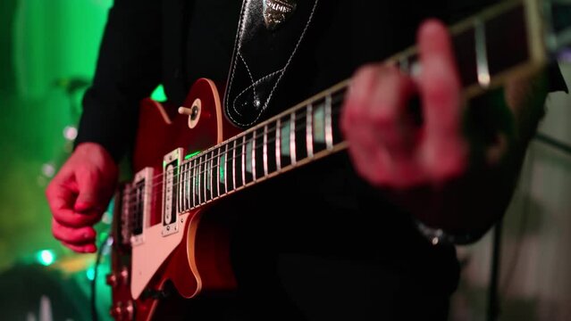 Man is playing guitar on stage.close up,Animation multicolor lights