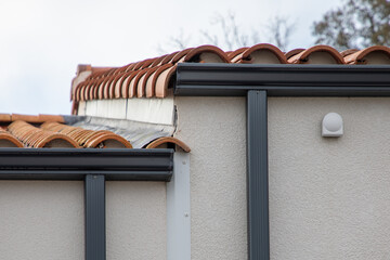 Corner of grey new modern house with roof gutter gray on facade home