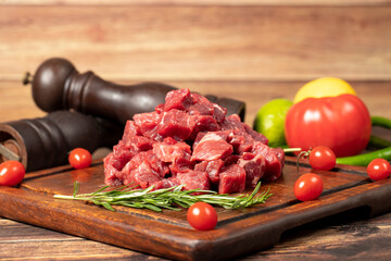 Raw fresh beef or lamb cubes. Diced red beef meat on a wood serving board. Raw casserole or stewing...