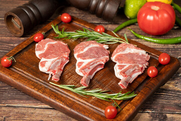 Raw lamb chops. Fresh raw lamb chops with spices and herbs. Wood background