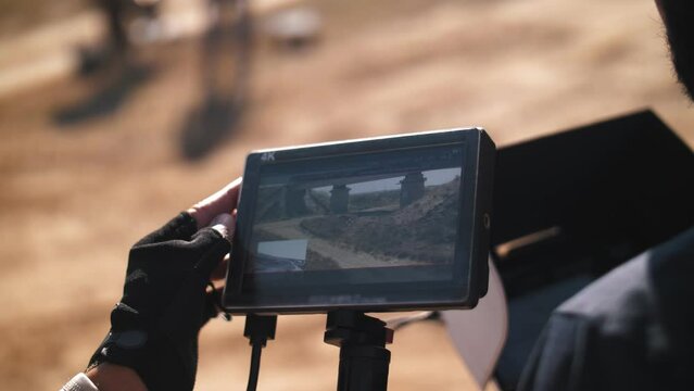 The operator looks at the monitor at the captured frames. film set in the steppe. Movie production