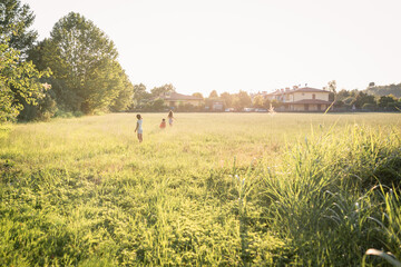 wide angle view on three children running in the field