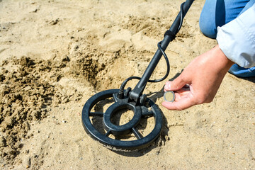 The digger found the coin using a metal detector. Adventures and treasure hunting