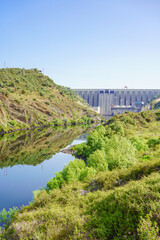 Fototapeta na wymiar View of The Alcántara Dam, also known as the José María de Oriol Dam, is a buttress dam on the Tagus River, province of Cáceres, Spain