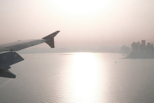 Cropped image of airplane flying over sea against sky during sunset