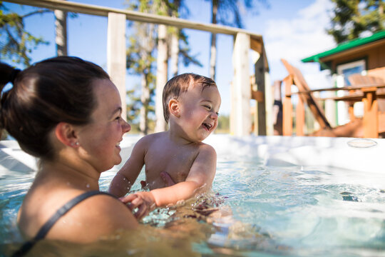 Happy mother and son swimming in pool