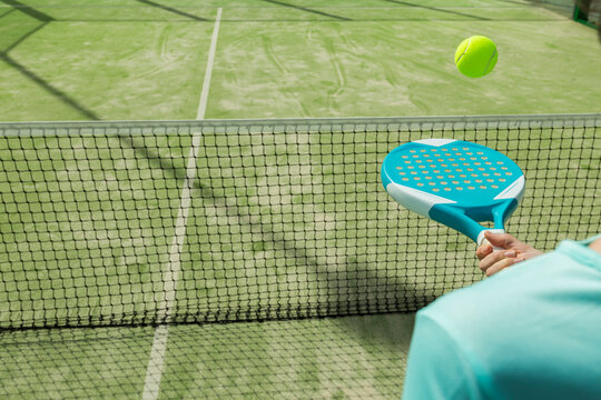 Midsection Of Woman Hitting Tennis Ball With Racket On Court