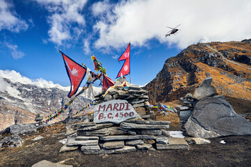 Low angle view of prayer flags on mountain against cloudy sky