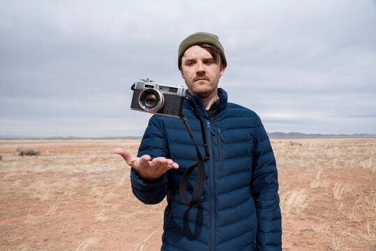 Man looking at camera in air at desert against sky