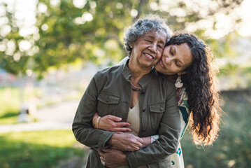 Daughter embracing mother while standing at park