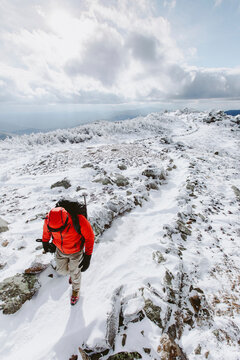 High angle view of backpacker wearing warm clothing walking on snow during winter
