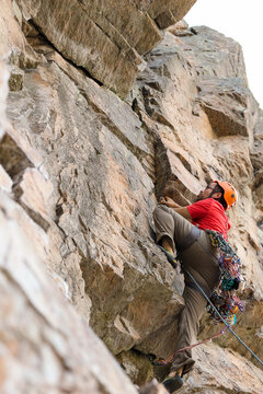 Low angle view of hiker climbing on rock formation