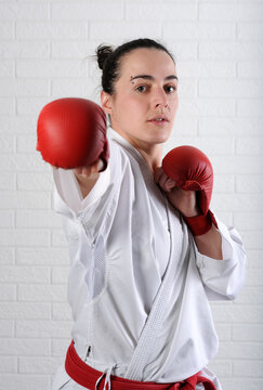 Portrait of confident woman practicing karate against wall