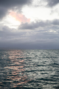 Scenic view of sea against cloudy sky during sunset