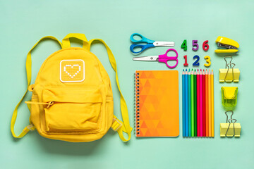 Back to school, education concept Yellow backpack with school supplies - notebook, pens, eraser rainbow, numbers isolated on green background Top view Copy space Flat lay composition Banner - 579968671
