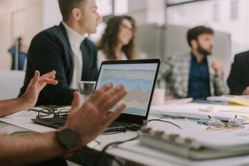 A close up photo of a businessman explaining financial stats to his coworkers
