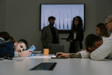 Overworked young male person felt asleep on the working desk at the middle of the presentation
