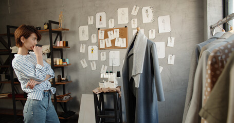 Hipster female fashion designer working with clothes on mannequin in her office, picking the best option for her customers - fashion, small business concept 