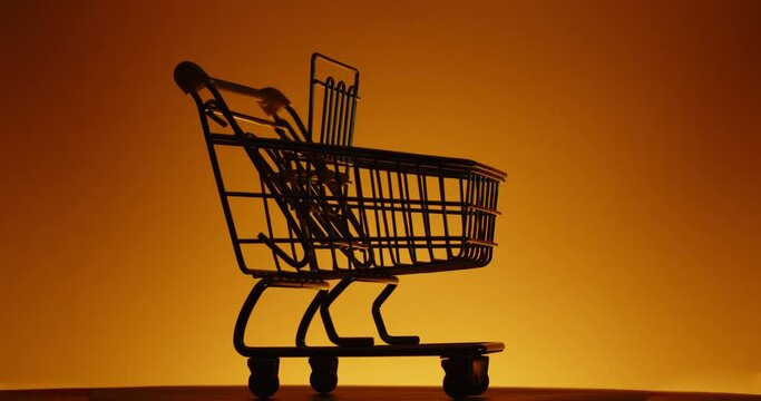 Empty shopping cart on color background with empty space for text. Shopping sale concept