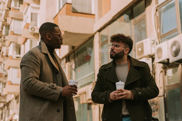 Two stylish business people having a serious conversation while hanging out in the city
