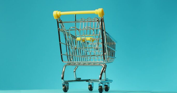 Empty shopping cart on color background with empty space for text. Shopping sale concept