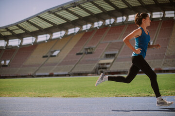Sporty girl running at the stadium