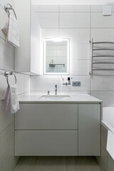 Modern bathroom in white washer and large mirror with backlight