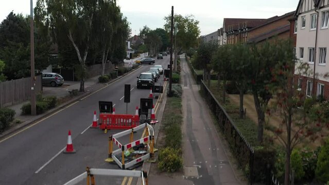 Automobiles wait on red light in front of road work site in UK