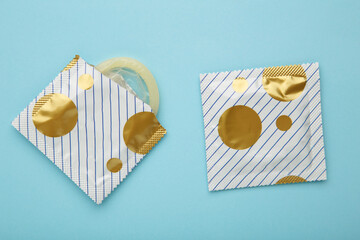 Condoms on blue background. A condom use to reduce the probability of pregnancy or sexually...