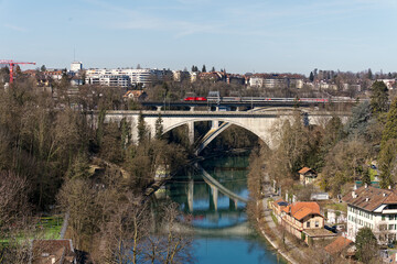 Obraz premium Bridges over Aare River with train crossing at Swiss City of Bern on a sunny winter day. Photo taken February 21st, 2023, Bern, Switzerland.