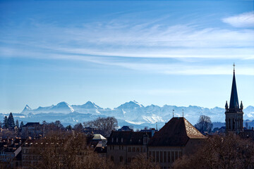 Scenic view of skyline at City of Bern with peaks Eigern, Monk and Virgin of the Bernese Alps in the background on a sunny winter day. Photo taken February 21st, 2023, Bern, Switzerland.