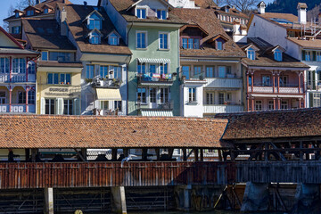 Scenic view over City of Thun with Aare River and covered wooden bridge on a sunny winter day. Photo taken February 21st, 2023, Thun, Switzerland.