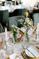 Hochzeitsdeko bei Hochzeitsfeier auf Holztisch mit Teller, Tischläufer und Blumen 