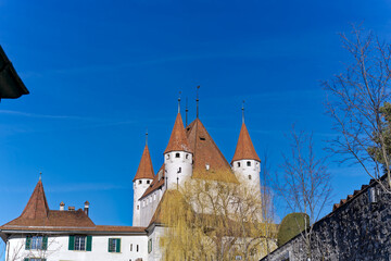Fototapeta na wymiar City of Thun with close-up of white castle on a hill in the background on a sunny winter day. Photo taken February 21st, 2023, Thun, Switzerland.