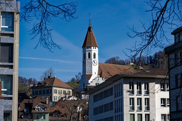 Old town of City of Thun with church and castle on a hill in the background on a sunny winter day. Photo taken February 21st, 2023, Thun, Switzerland.
