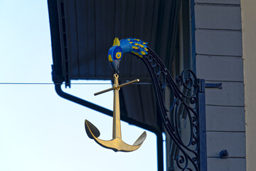 Close-up of wrought iron sign with golden anchor and bird's head at the old town of Swiss City of Thun. Photo taken February 21st, 2023, Thun, Switzerland.