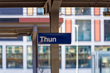 Fototapeta premium Close-up of blue and white sign at railway station of Swiss City of Thun on a sunny winter day. Photo taken February 21st, 2023, Thun, Switzerland.