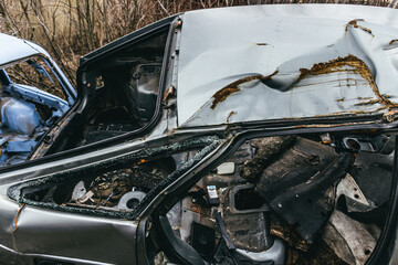 A dump of broken rusted cars, their parts and tires