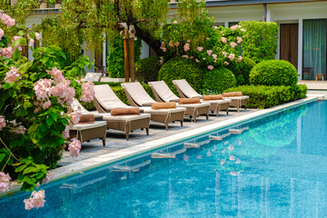 Luxury 5 star hotel pool in Asia with chairs.