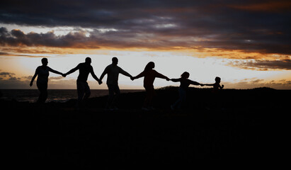 Sunset, beach and silhouette of family with children by ocean for bonding, quality time and peace. Shadow, nature and grandparents, parents and kids holding hands on vacation, holiday and weekend