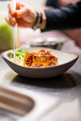 chef hand cooking donburi bowl food in the restaurant kitchen