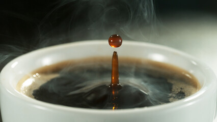 Detail of coffee drop falling into cup of coffee.