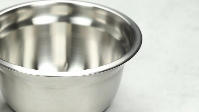 Empty stainless steel bowl set, kitchen accessories on a bright table. Fast pano from left to right