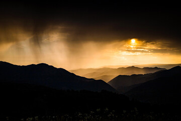 Obraz premium banner of mountain peaks in beautiful stormy sunset light