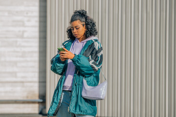 fashionable urban girl on the street with mobile phone