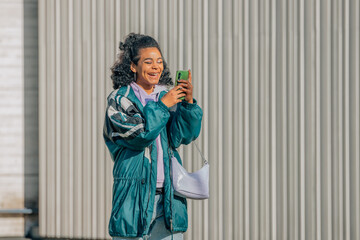 fashionable urban girl on the street with mobile phone