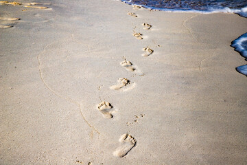 Fototapeta na wymiar footsteps in golden sand texture summer fun