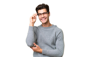 Young handsome caucasian man over isolated background with glasses and happy