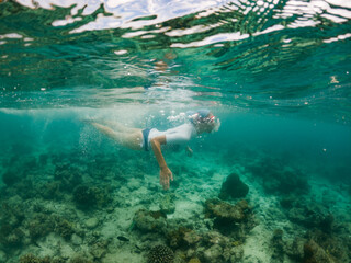 woman snorkeling in clear tropical sea