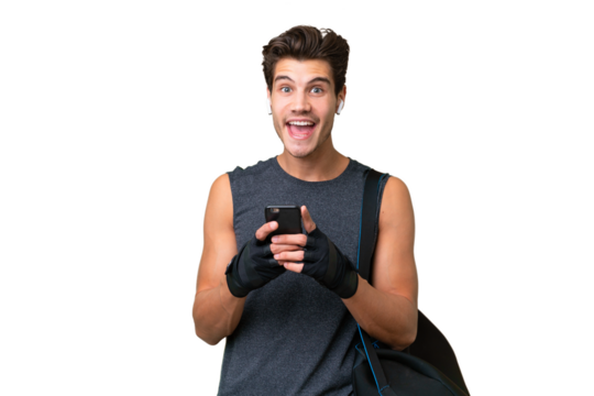 Young sport caucasian man with sport bag over over isolated background surprised and sending a message